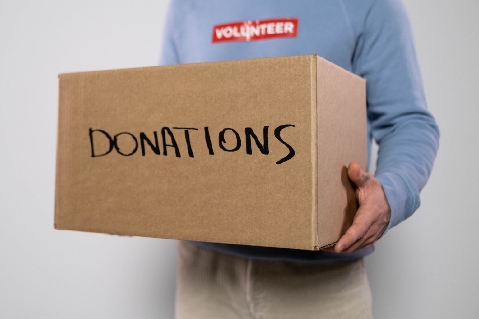 Person Holding a Box With Donations